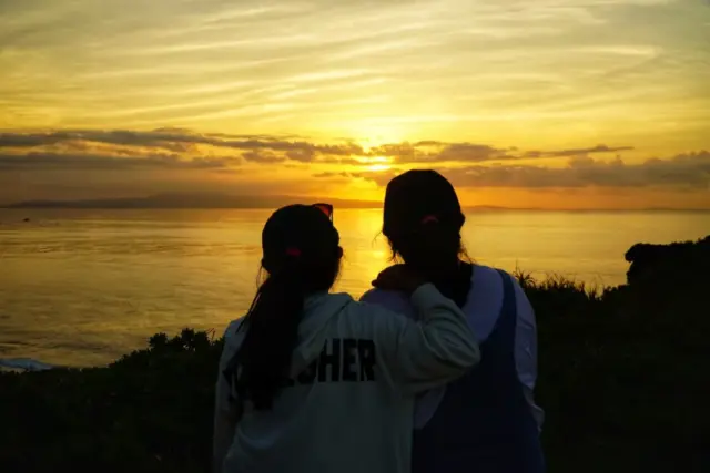 美しい夕日を眺める姉妹